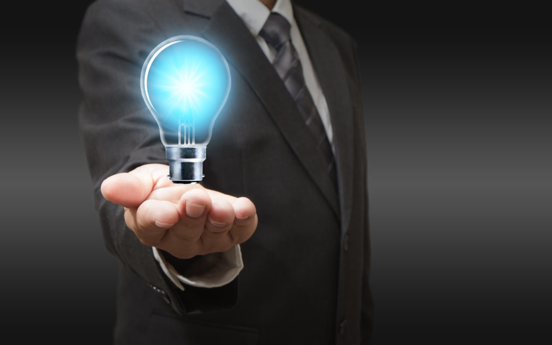 Businessman holding a glowing light bulb, symbolizing electrical solutions and preparedness for power outages during storms.