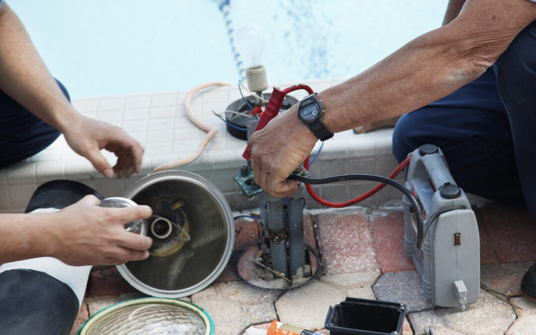 Technician performing maintenance on pool electrical equipment, inspecting wiring and connections near the water, emphasizing safety and upkeep for longevity.