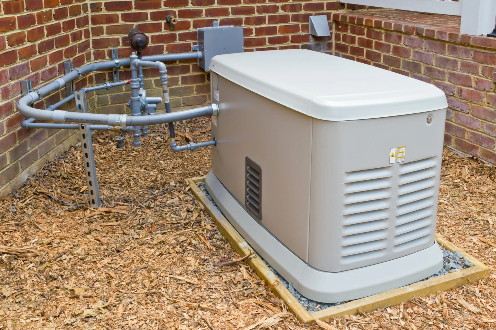 Standby generator system installed outside a commercial property, surrounded by piping and wood chips, emphasizing Kazar's Electric's expertise in generator installation.