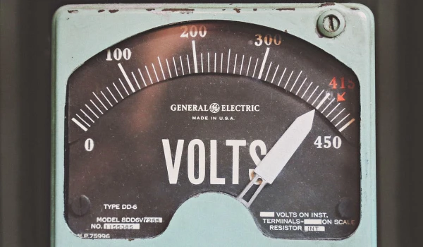 Vintage General Electric voltmeter displaying voltage levels, emphasizing electrical safety and the importance of professional emergency electrical services.