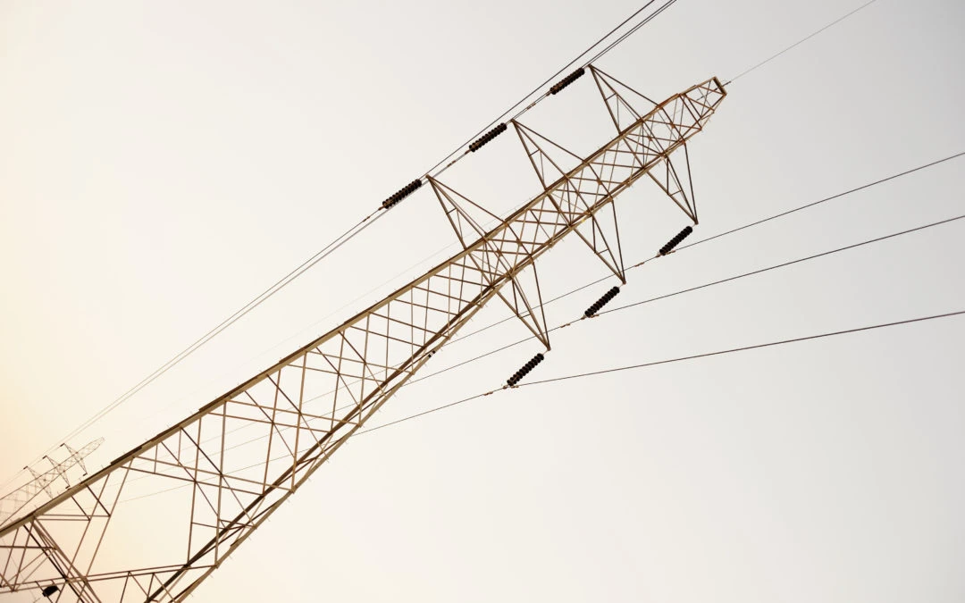 Power transmission tower against a clear sky, symbolizing energy infrastructure and rising energy consumption trends.